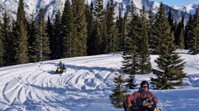 a man riding a snowboard down a snow covered slope